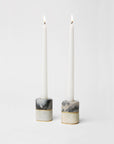 Lunario candle holders with marbled design holding lit candles