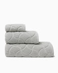 Oasi platinum bath towel, hand towel, and wascloth folded and stacked side view