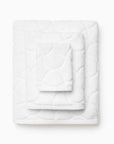 Oasi white bath towels stacked, top to bottom: washcloth, hand towel, bath towel.