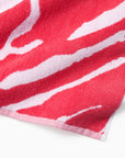 Close-up of a coral and white patterned sampieri beach towel