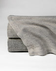 The SFERRA Celine herringbone blanket woven in soft colors with cream.