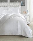 SFERRA Adelli prewashed textured cotton Coverlet on an all-white bed.