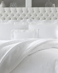 SFERRA Adelli prewashed textured cotton Coverlet on an all-white bed.