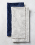 SFERRA Acanthus dinner napkins with a floral pattern laid out against a marble background.