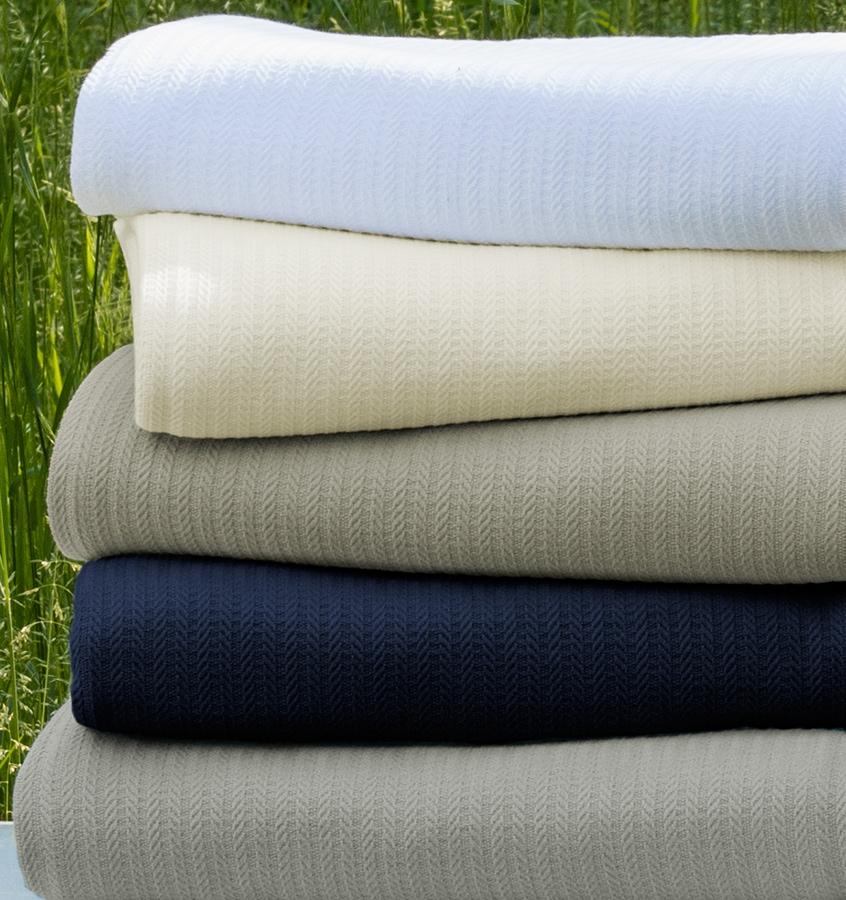 The SFERRA Grant classic cotton blanket in white, ivory, grey, and navy.