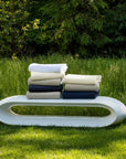 The SFERRA Grant classic cotton blanket in white, ivory, grey, and navy.