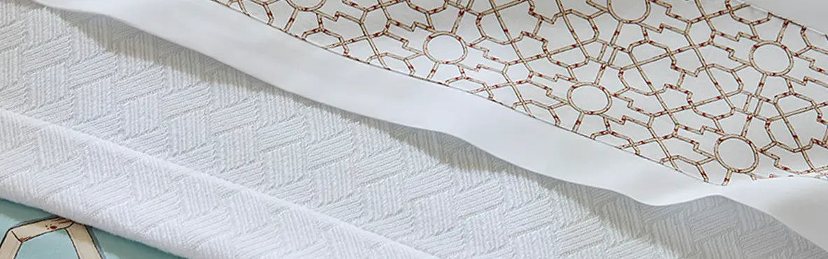 A corner shot of a pink patterned SFERRA bed.