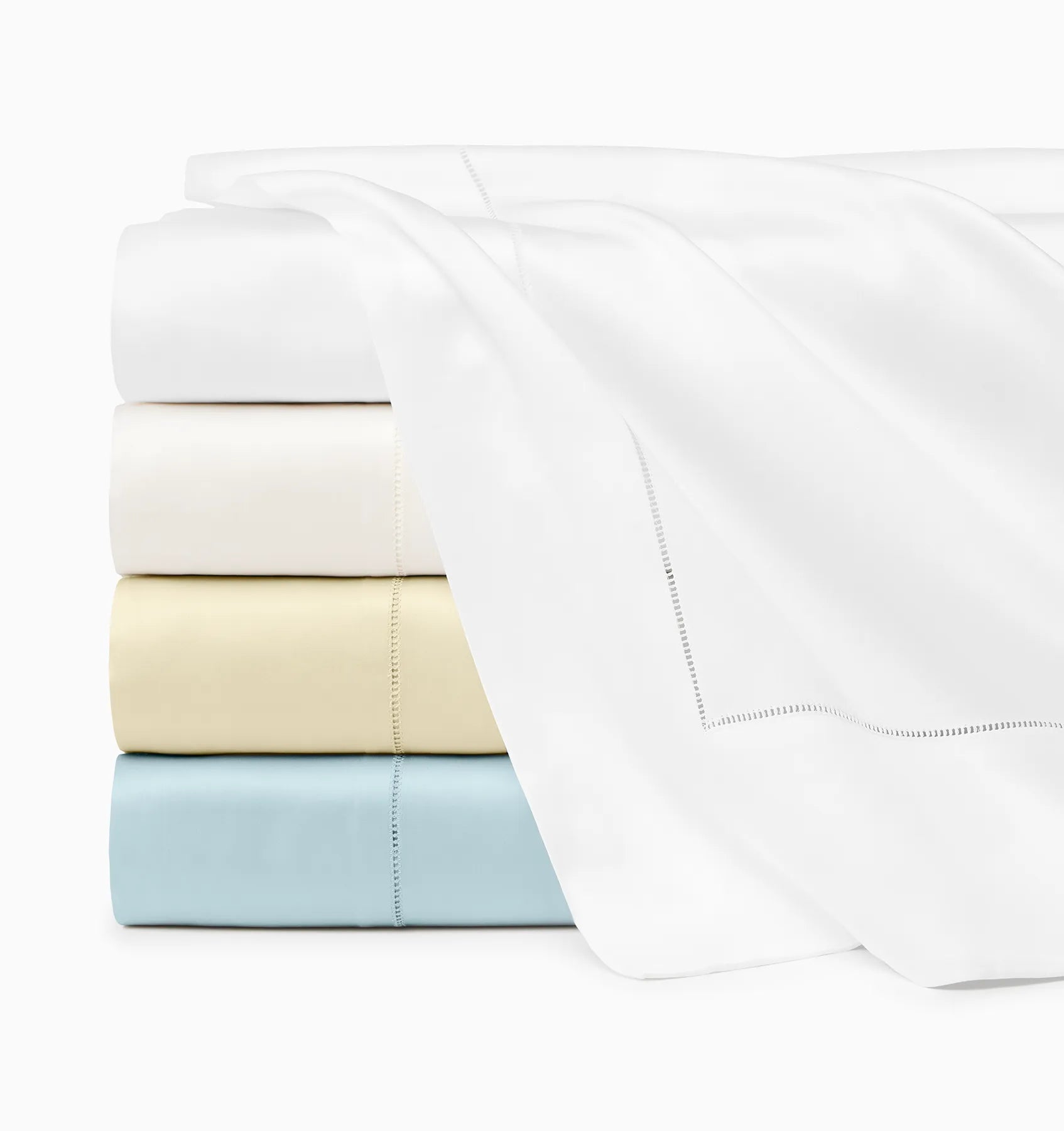 Stack showing Ariel flat sheet folded in all colors. Top to bottom: White, oyster parchment & artic. 