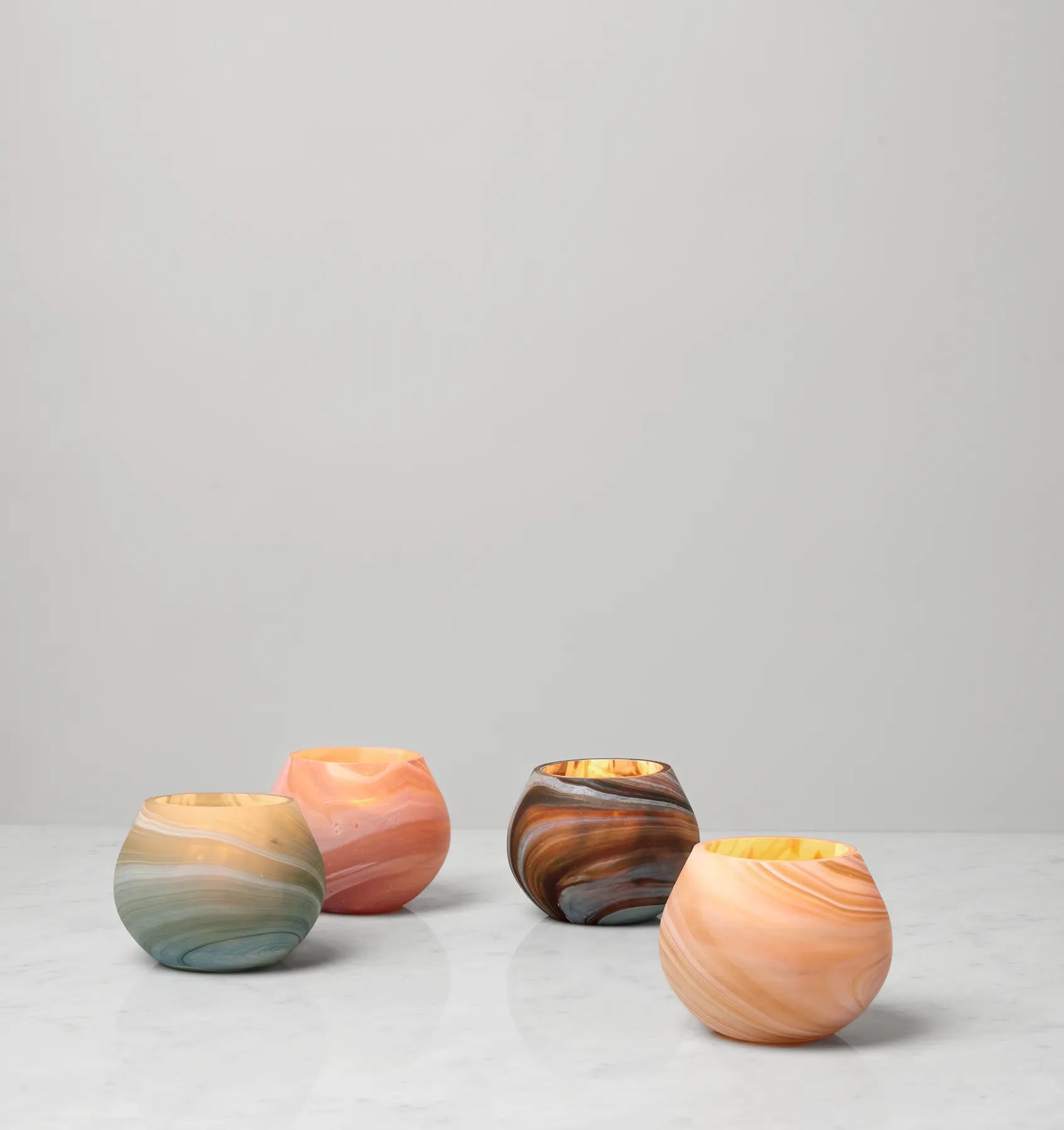 Giove votive candle holders lit with a candle inside