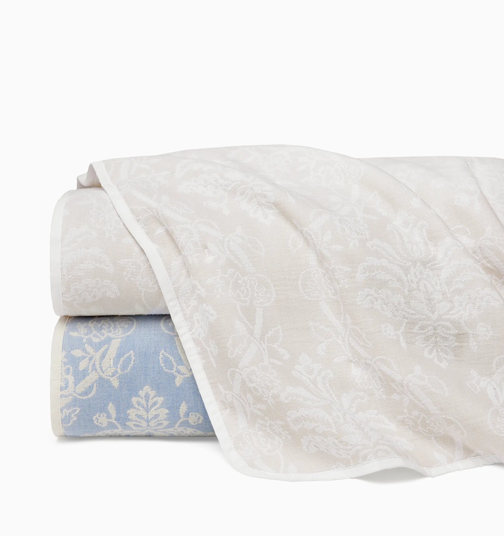 Isabella quilt in ivory/sand and ivory/sea stacked and folded