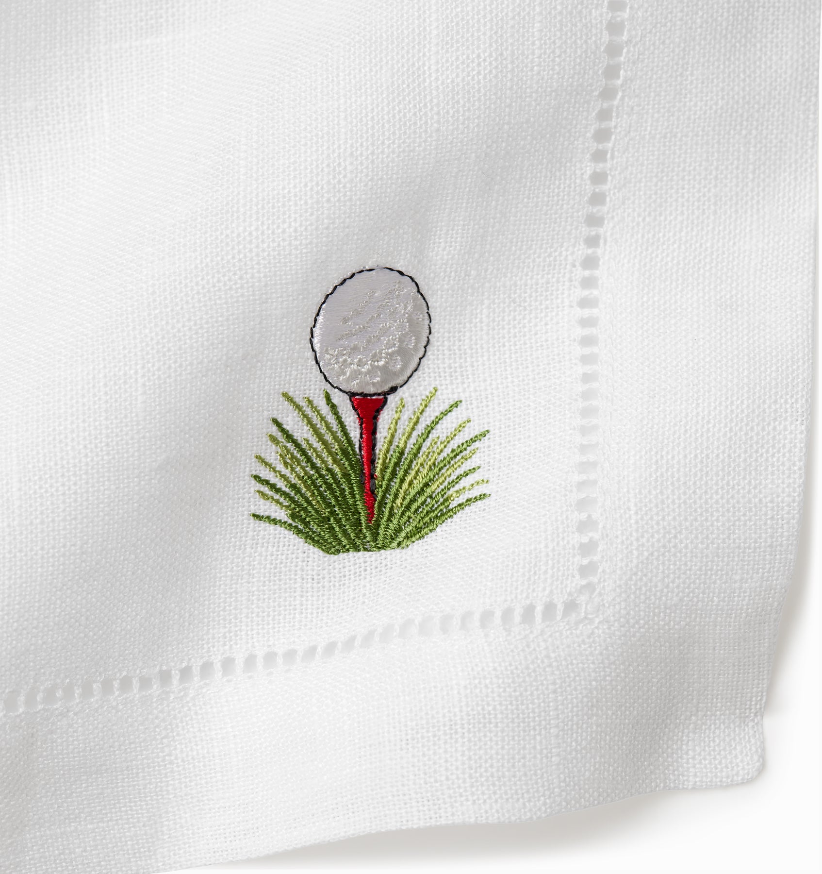 Golf cocktail napkins with tee and golf ball in the grass. 