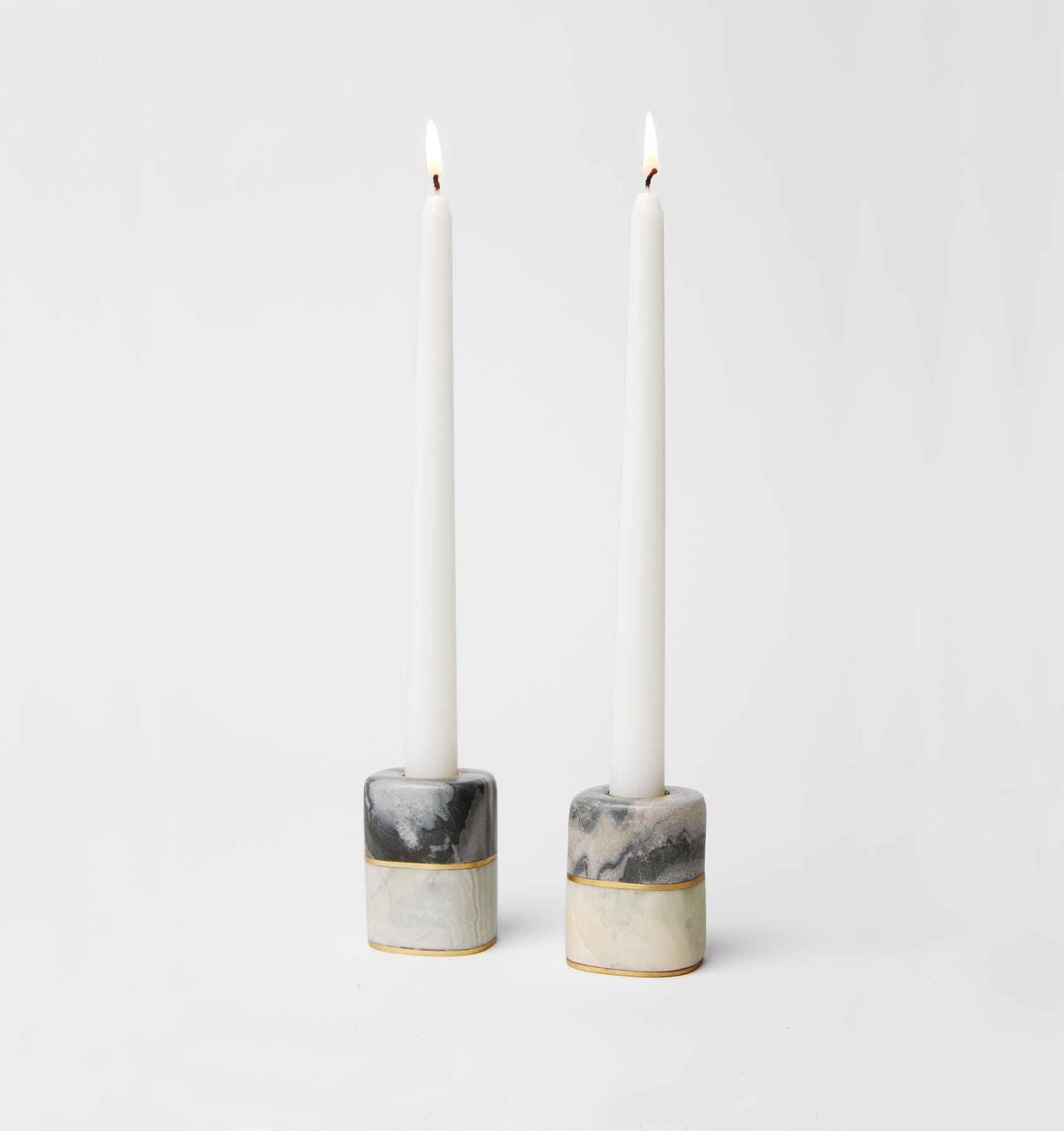 Lunario candle holders with marbled design holding lit candles