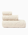 Oasi ivory bath towel, hand towel, and wascloth folded and stacked side view