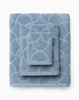 Oasi sea bath towel, hand towel, and wascloth folded and stacked.
