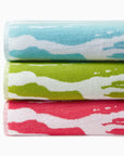 Sampieri beach towels folded and stacked in colors clearwater, kiwi and coral