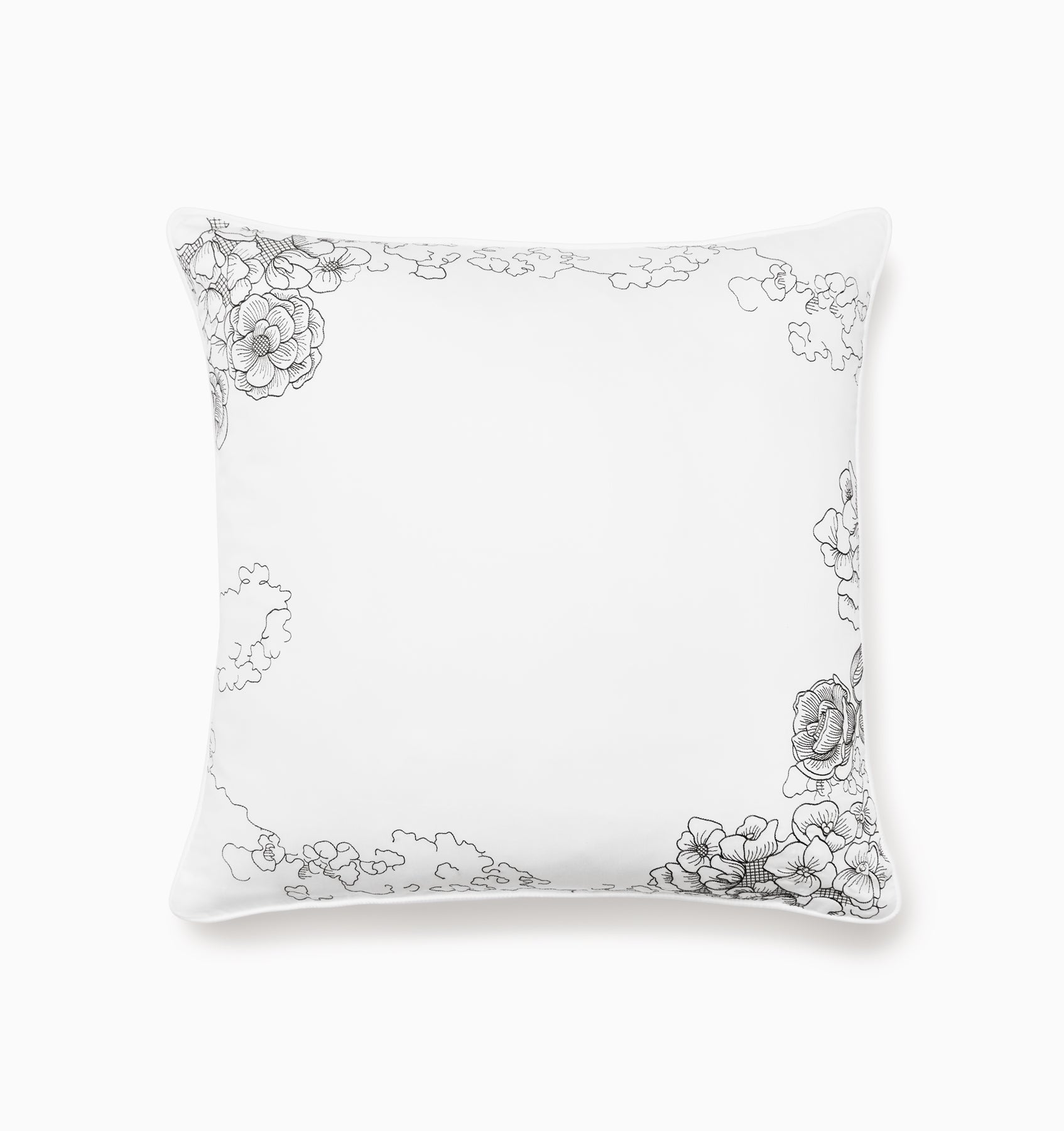 White pillow with black floral embroidery on a white background