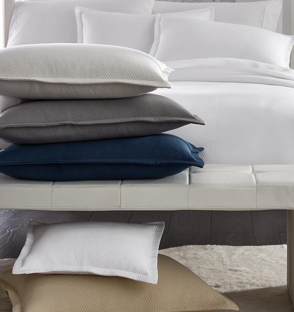 SFERRA Perrio Coverlet with a stack of Perrio Shams