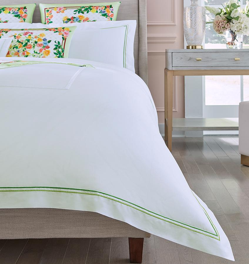 Left half of the SFERRA Moda Egyptian cotton duvet cover with coordinating pillows and floral silk shams.