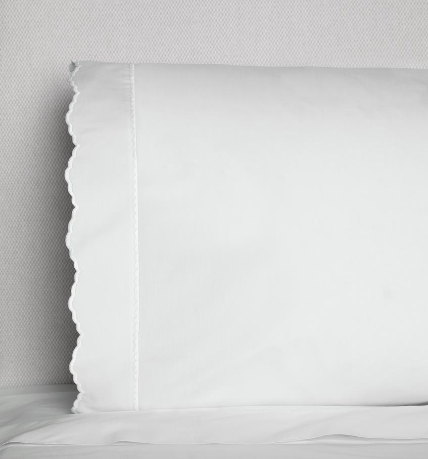 A white SFERRA Pettine pillowcase with scalloped edges against a white background. 