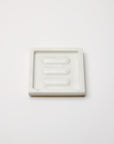 A rectangular marble SFERRA Pietra soap dish against a grey background.