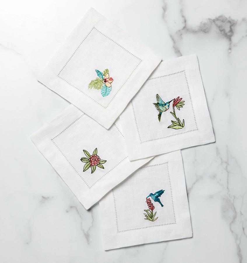Inspired by the tropics, these whimsical cocktail napkins feature flora and birds embroidered against white hemstitched linen.