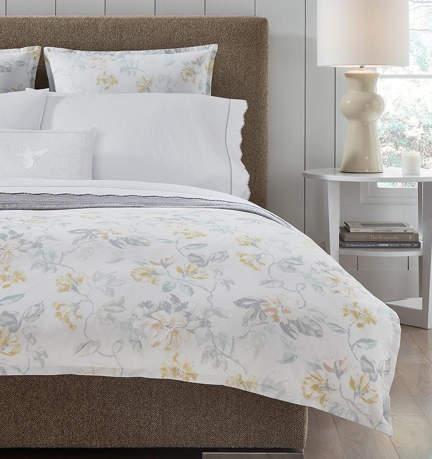 Brown bed with white cotton percale bedding with a light yellow floral motif.