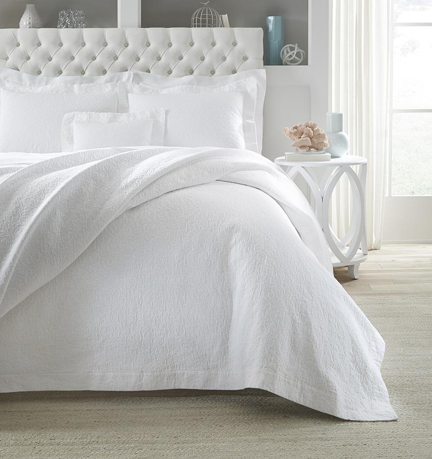 SFERRA Adelli prewashed textured cotton Coverlet on an all-white bed. 