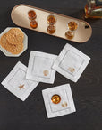 SFERRA Beachcomber cocktail napkins feature four delightful seashell embroideries in golden hues on hemstitched linen napkins.