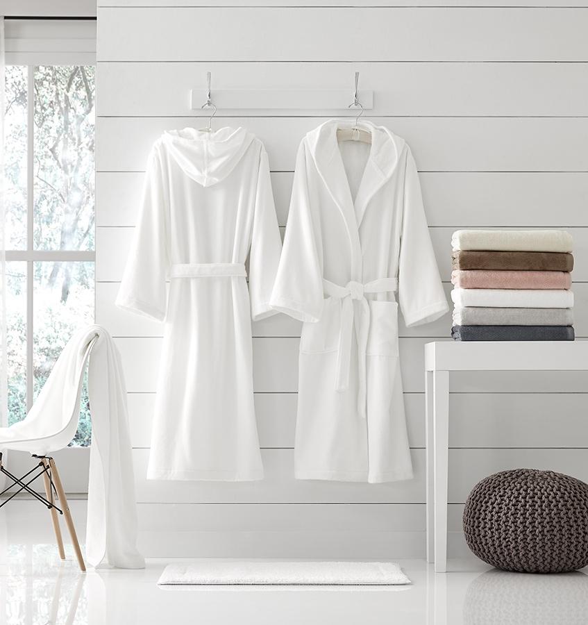 SFERRA luxury bath robes hung against a bathroom wall. 