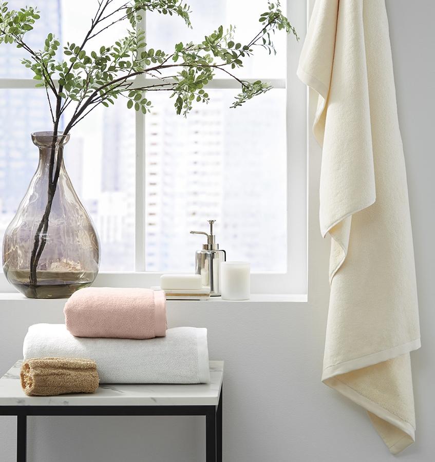 A window scene with SFERRA luxury bath towels sitting on a table.