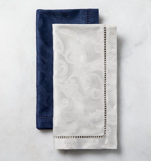 SFERRA Acanthus dinner napkins with a floral pattern laid out against a marble background.