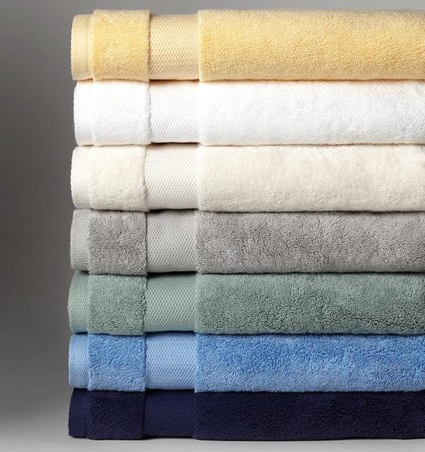 A stack of SFERRA Bello luxury bath towels in 7 different colors.
