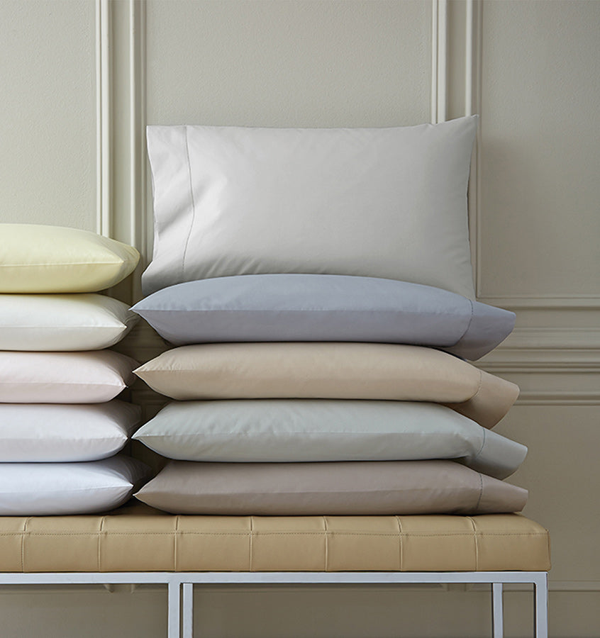 Stacks of pillows with SFERRA Celeste percale pillowcases, woven in Italy from pure, extra-long-staple cotton for a super soft hand.