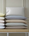 Stacks of pillows with SFERRA Celeste percale pillowcases, woven in Italy from pure, extra-long-staple cotton for a super soft hand.