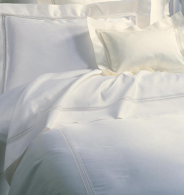 On the Diamante Duvet Cover, a macramé lace inset is threaded through its center with a thin, satin ribbon that frames the border of sateen.