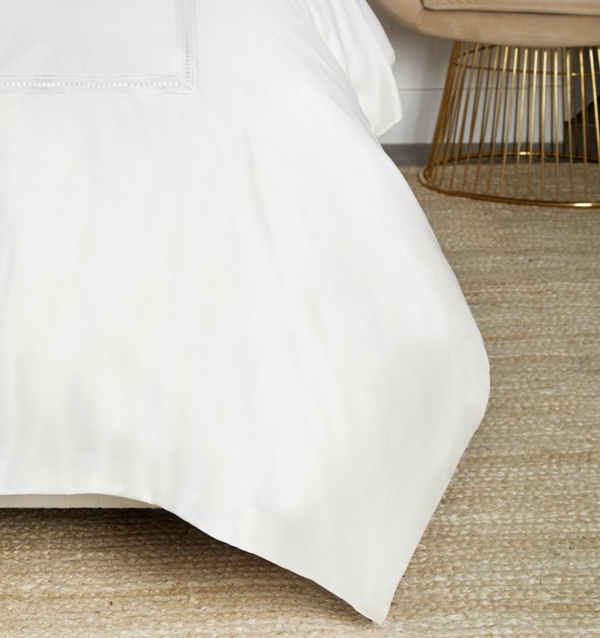 On the Diamante Duvet Cover, a macramé lace inset is threaded through its center with a thin, satin ribbon that frames the border of sateen.