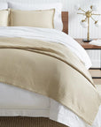 SFERRA Favo Coverlet in beige with a honeycomb pattern.