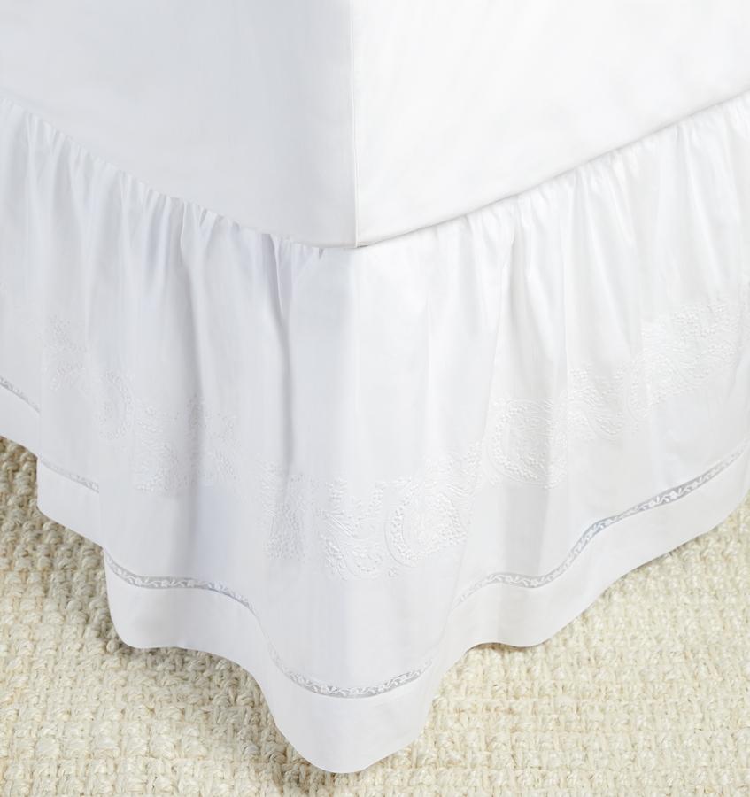 A luxury SFERRA Francesca bed skirt in a white hand-embroidered cotton with a lace inset.