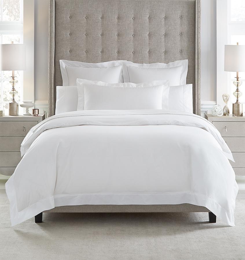 An all-white bed with SFERRA Giza 45 Percale bedding, grown in the Nile river valley, woven by master craftsmen in Italy, and made of the finest cotton in the world.