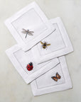 SFERRA Insetti cocktail napkins feature endearing insects on white hemstitched linen napkins.