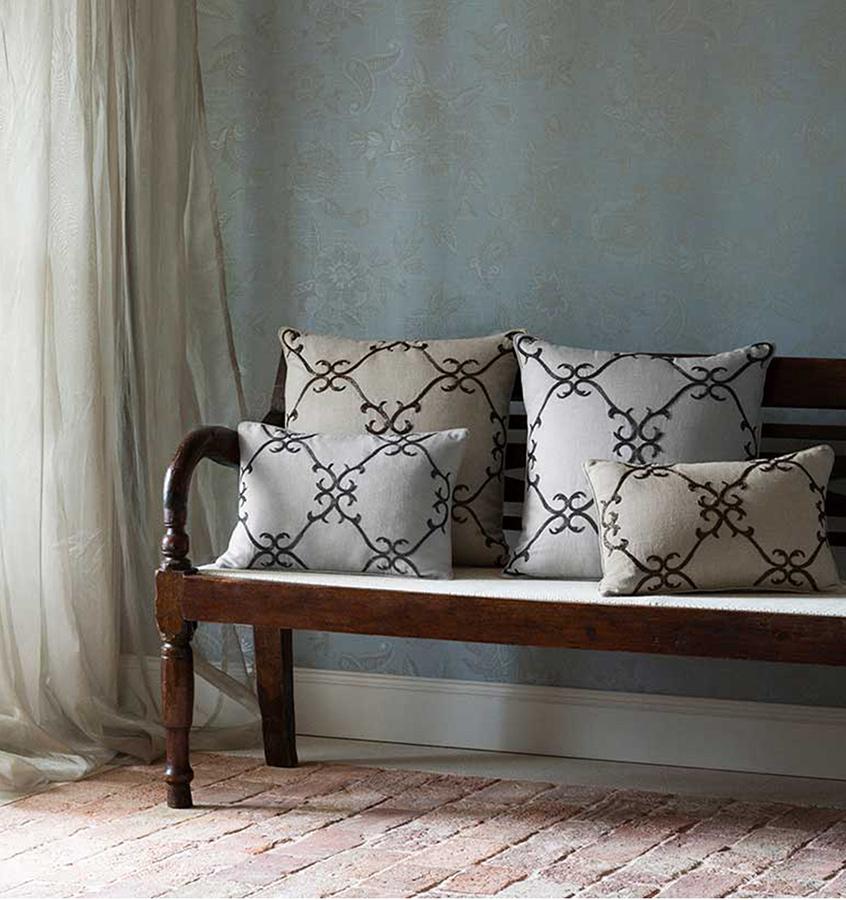 Solari pillows bear a lovely geometric scroll motif, meticulously hand-stitched with elegant beadwork in shimmery shades of dark platinum and copper. 
