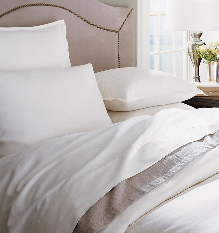 A bed with SFERRA Tesoro luxury bedding, crafted from the finest cotton in the world.